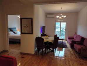 Cozy living space with a dining area and bedroom, featuring a dining table, chairs, sofa, and bed with a headboard.