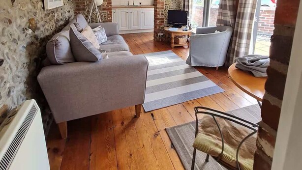 Un salon confortable avec un canapé, un téléviseur et un coin repas comprenant une table et des chaises.