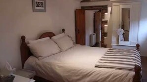 Une chambre à coucher avec un lit en bois, une table de chevet et une armoire.