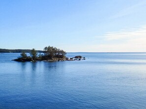 A calm body of water with a small island featuring trees and rocks. - 4 Star Holiday Home in Ammeberg (Åmmeberg)