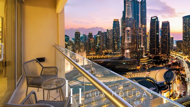 A balcony with a cityscape view, including tall buildings and a stadium.