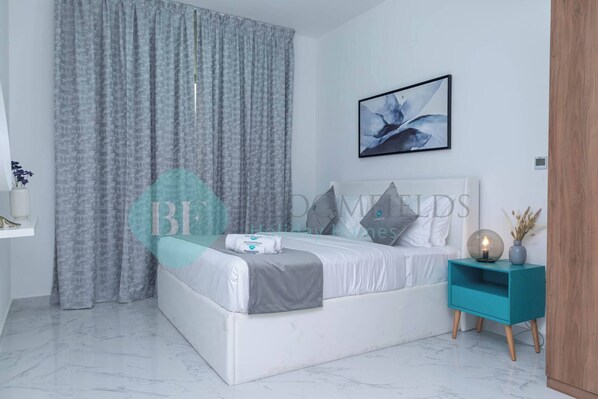 Un dormitorio moderno con cama, mesita de noche y una obra de arte en la pared.