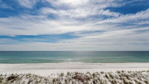 Une plage de sable blanc, sous un ciel dégagé.