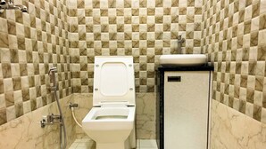 A bathroom with a toilet, a sink, and a shower. - Hotel Pragati Heights (Mathura)
