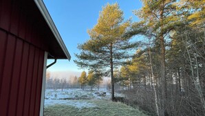 A red building with a sloped roof, surrounded by a snowy landscape and a dense forest. - 2 Person Holiday Park Home in Orsa (Orsa)