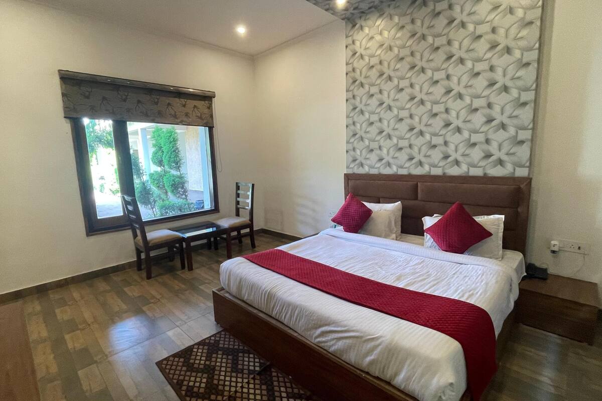 A hotel room with a bed, a desk, and a chair.