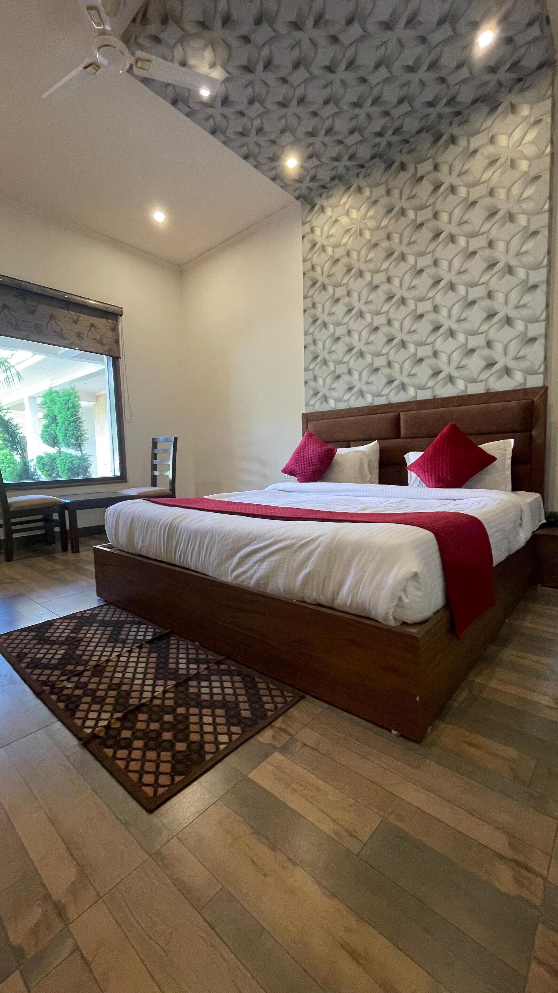 A bedroom with a large bed, wooden headboard, and a patterned wall.