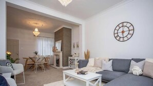 Ein Wohnzimmer mit einer Couch, einem Couchtisch und einem Essbereich mit Stühlen und einem Tisch.