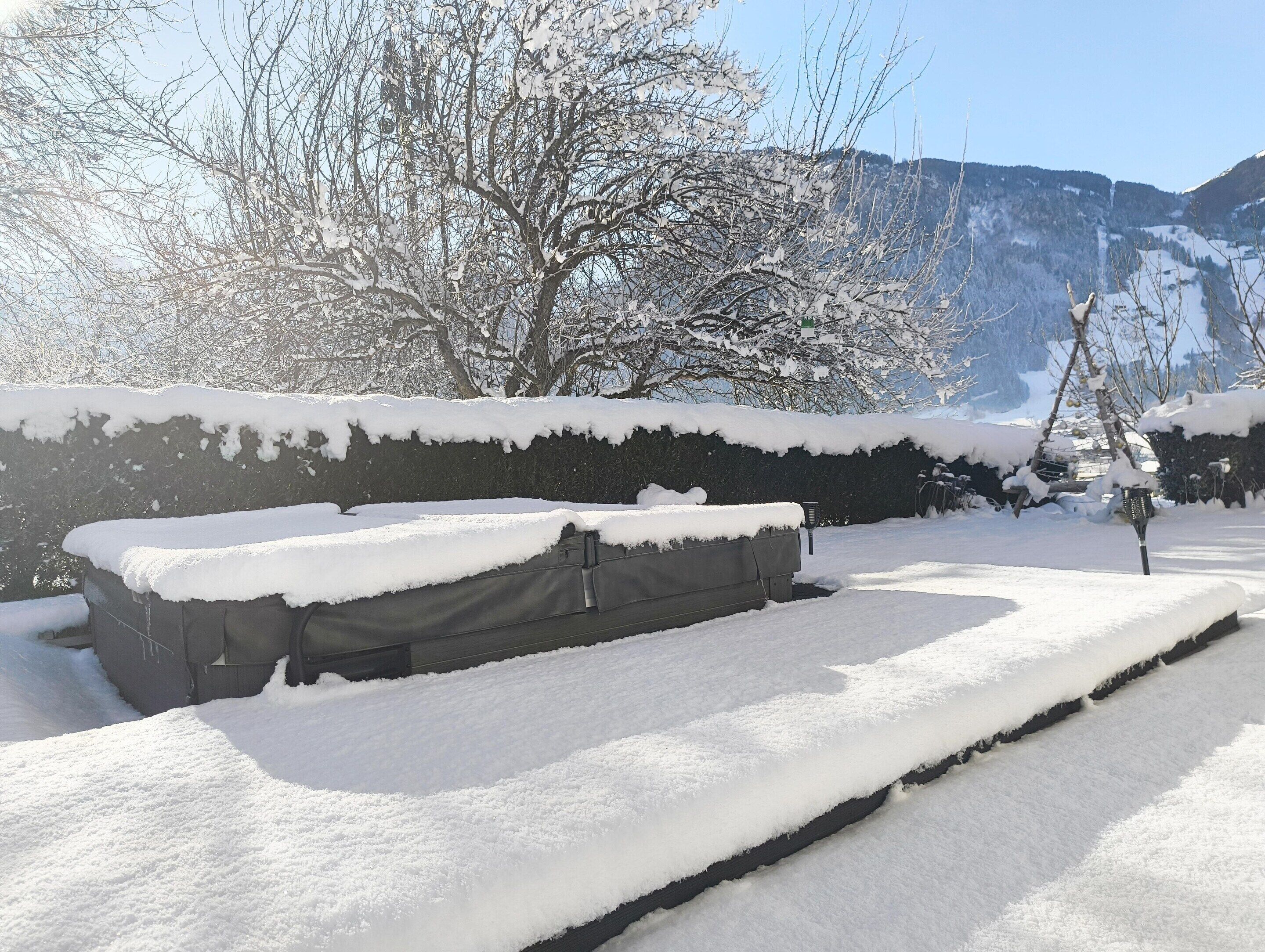 Un'area scoperta innevata con una panchina e un muro.