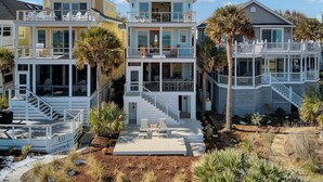 A multi-story beachfront house with balconies, a covered patio, and a view of the ocean. - New Construction 5BR | Designer Coastal Home in Wild Dunes (Isle of Palms)