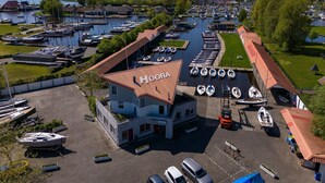 A marina with multiple boats docked, a building labeled "Hoora," and a clear view of the surrounding area including a church and open water. - Houseboat in Heeg With Stunning Marina Views (Heeg)