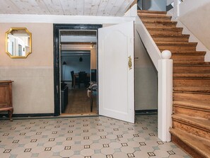 A staircase with wooden steps and a white handrail, leading to an open door. - 4 Star Holiday Home in Hojer (Højer)