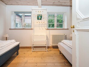 A room with two beds, a radiator, and a window with a view of greenery. - 4 Star Holiday Home in Hojer (Højer)