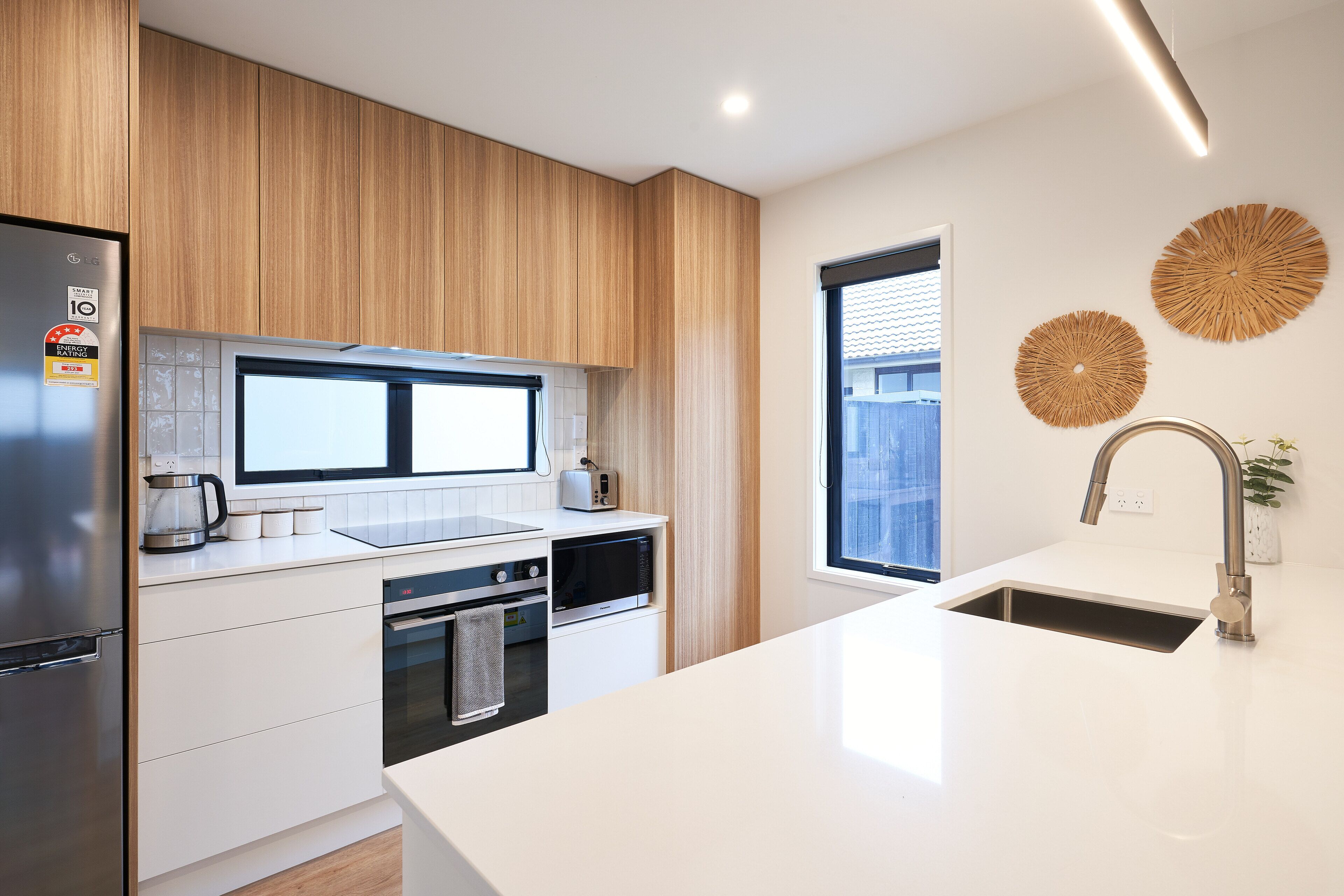 A modern kitchen with a stainless steel refrigerator, a microwave, and a sink with a faucet.