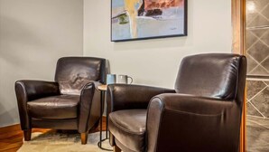 Two leather armchairs in a room with a painting on the wall and a tiled floor. - Stunning Views at Chateau LeConte • Hot Tub (Gatlinburg)