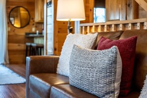 A leather sofa with three cushions in a wooden interior space.