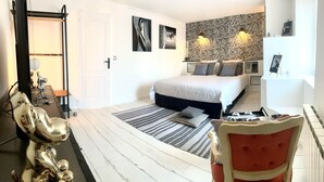 Une chambre moderne avec un grand lit, un mur à motifs zébrés et une décoration minimaliste.