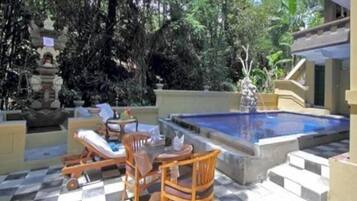 Een buitenzwembad, ligstoelen bij het zwembad