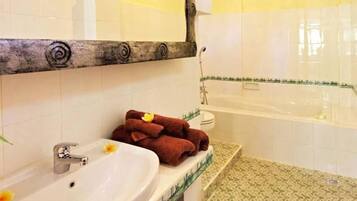 Een bad/douchecombinatie, handdoeken, zeep, shampoo