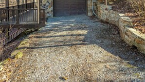 Una casa de dos pisos con base de piedra, un porche cubierto y un garaje.