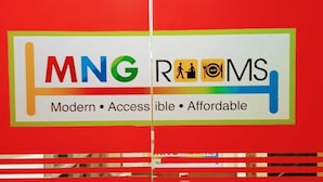 Een bord met de tekst 'MNG ROOMS' en de woorden 'Modern • Toegankelijk • Betaalbaar' op een rode achtergrond.