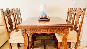 A dining table with ornate wooden chairs, a table lamp, and a patterned floor. - A DIFFERENT SPACE IN TRIANA (Sevilla)