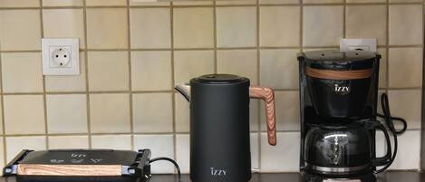 A kitchen with a coffee maker and a portable heater on the counter.