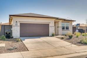 A single-story house with a brown garage door, a stone exterior, and a landscaped front yard. - 15 Mi to Dtwn Sacramento: Newly Built Home! (Sacramento)