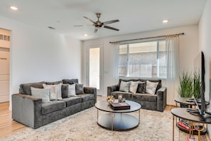 A modern living room with two grey sofas, a round coffee table, and a ceiling fan. - 15 Mi to Dtwn Sacramento: Newly Built Home! (Sacramento)