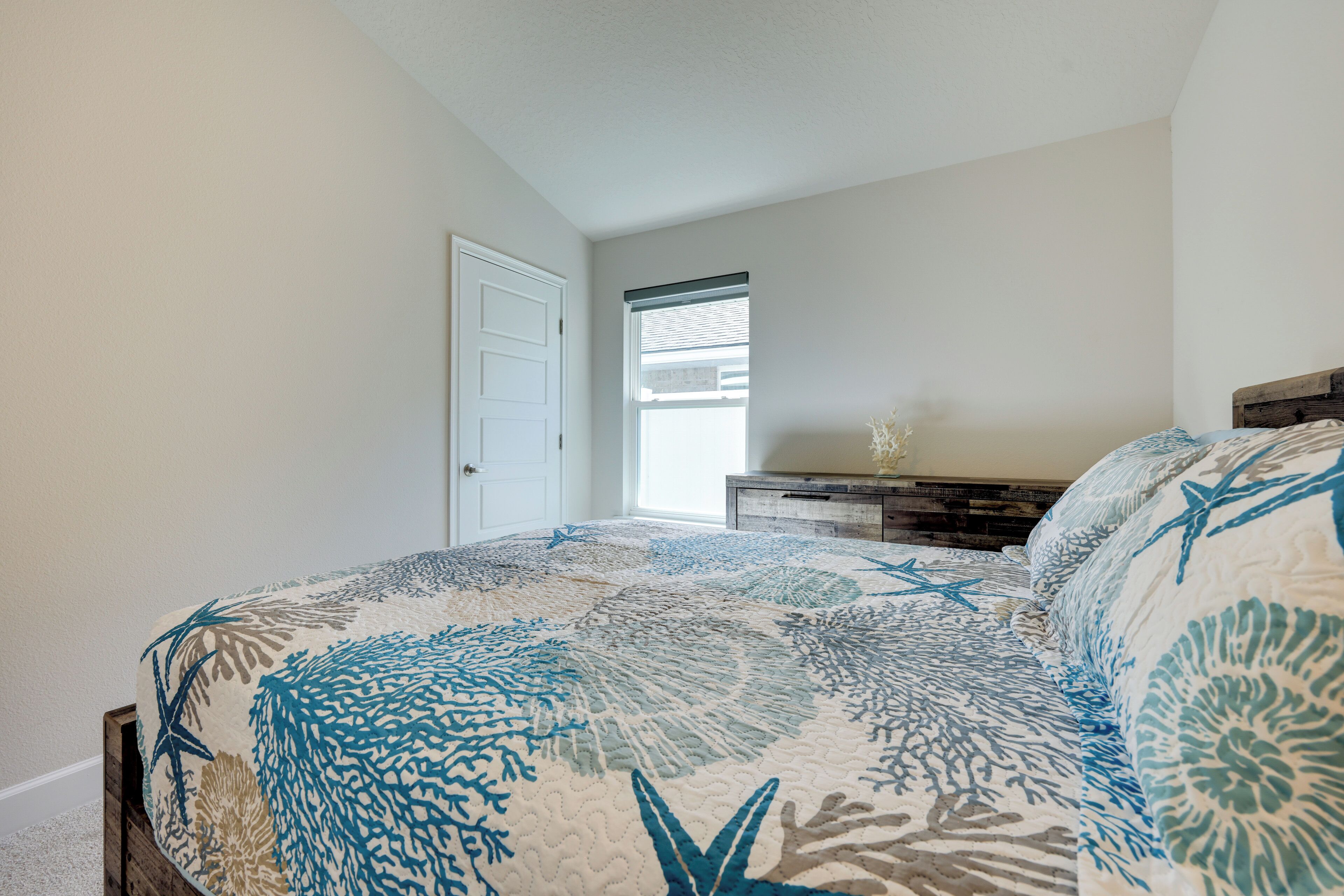 Une chambre à coucher avec un lit, une commode et une fenêtre.