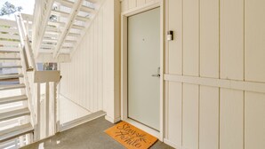 A white door with a doormat that reads "Stay awhile". - < 1 Mi to Coligny Beach Park: Condo w/ Tennis! (Hilton Head Island)