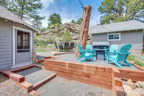 A patio with outdoor furniture, a wooden deck, and a natural landscape with trees and rocks. - Steps to Estes Lake: Mtn-view Hideaway w/ Hot Tub! (Estes Park)