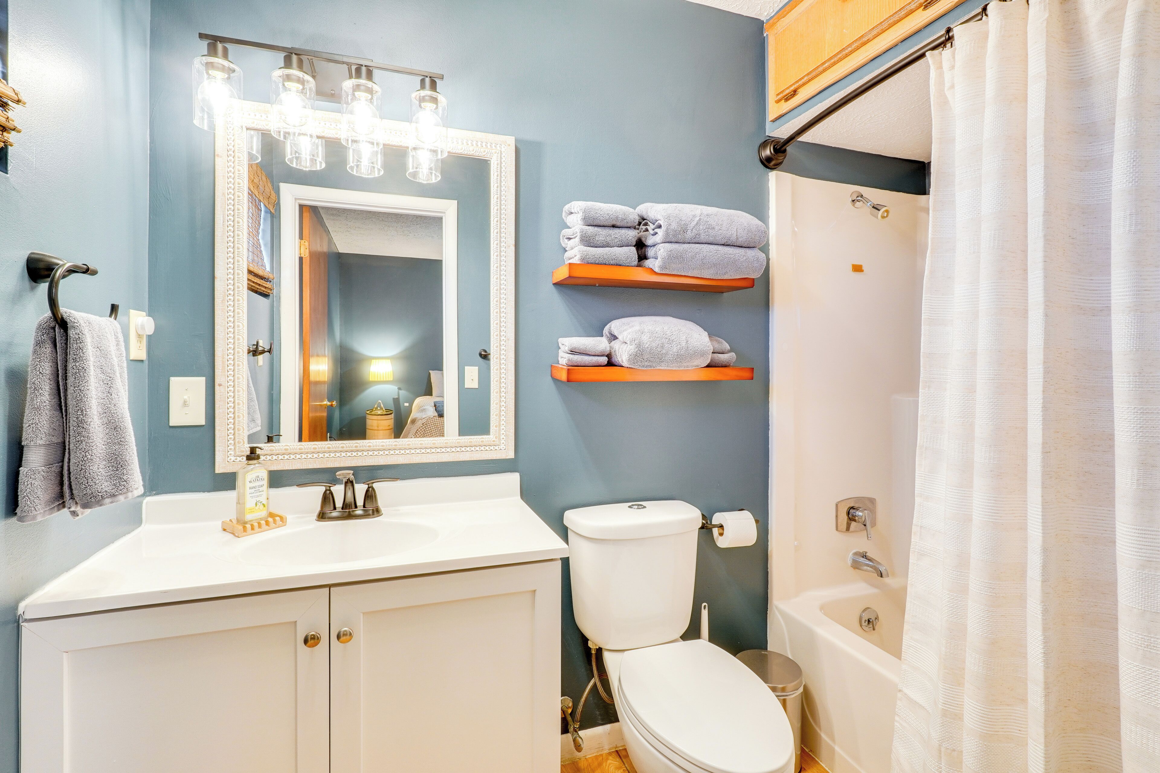 Une salle de bain avec un lavabo blanc, des toilettes, une baignoire et un rideau de douche.