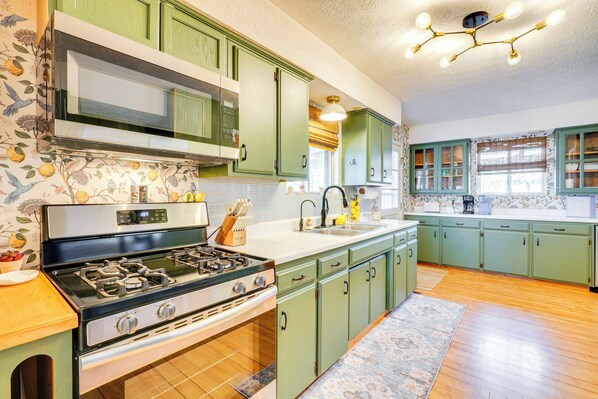 A kitchen with green cabinets, a stove, and a sink. - Deck & Lake Views: Modern Eagle Rock Gem (Eagle Rock)