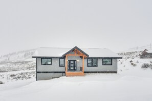 A modern house with a snow-covered landscape.