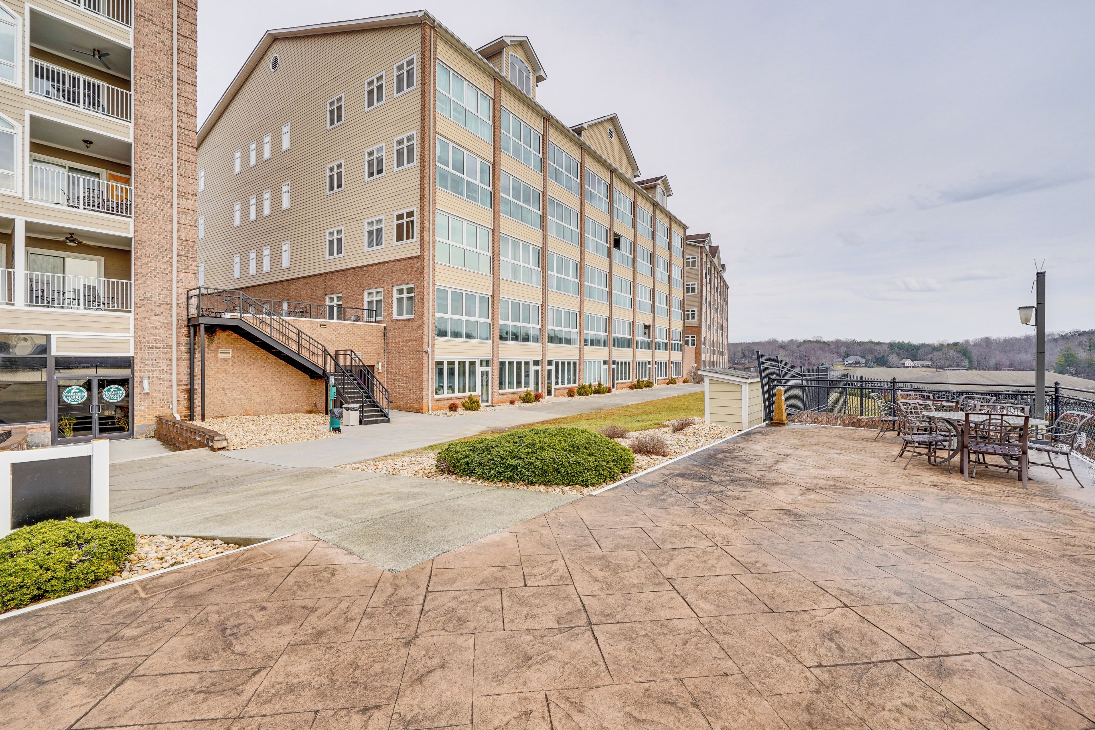 A multi-story hotel with a brick facade, large windows, and a covered outdoor area with seating.