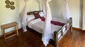 A bed with a wooden frame and a white canopy. There is a small wooden bench beside the bed. - savannah murchison lodge (Paraa)