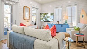 A spacious living room with a large sofa, a small coffee table, and a blue cabinet.