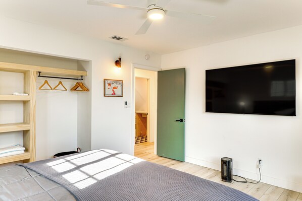 A modern bedroom with a bed, a wardrobe, a television, and a ceiling fan. - Fish, Hike & Explore: Cabin w/ Yard in Big Bear (Big Bear City)