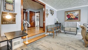 A room with a wooden staircase, a dining table, a bench, and a patterned carpet. - 4 Mi to Dtwn Kalamazoo: Central Apt (Kalamazoo)