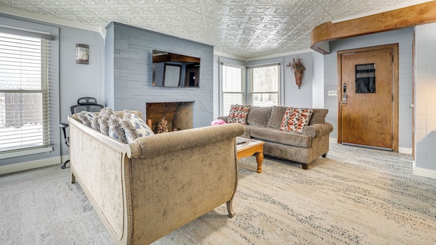 A living room with a fireplace, two sofas, a coffee table, and a patterned carpet. - 4 Mi to Dtwn Kalamazoo: Central Apt (Kalamazoo)