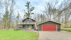 A two-story house with a large deck and a garage.
