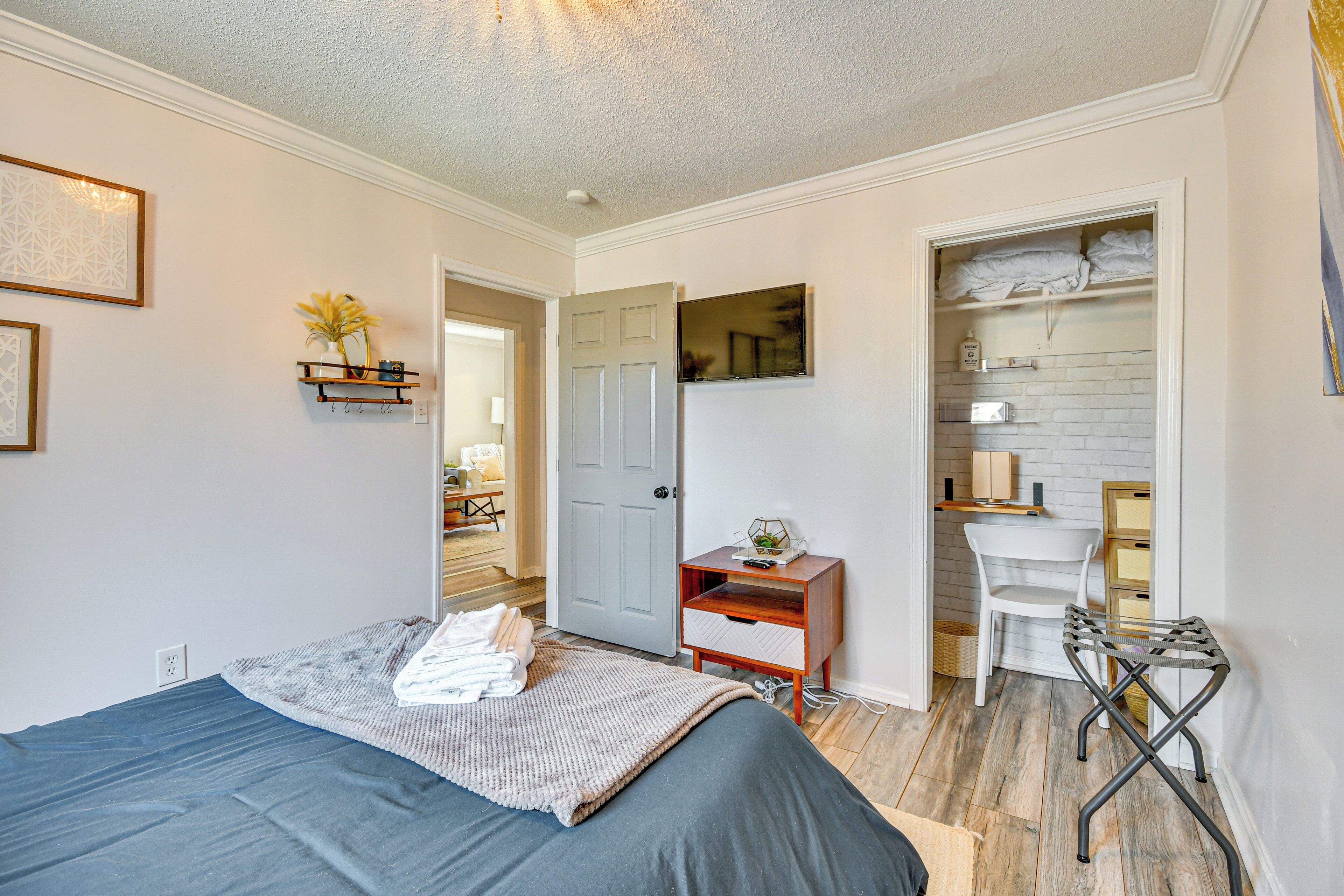 A bedroom with a bed, a desk, a chair, and a wardrobe.