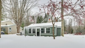 Una casa cubierta de nieve con un porche y un garaje.
