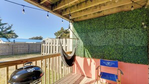 A wooden deck with a barbecue grill, a hammock, and a folding chair. - Walk to Atlantic Beach: Townhome w/ Patio! (Atlantic Beach)