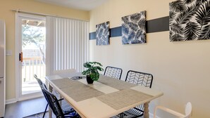 A dining area with a table, chairs, and artwork on the wall. - Walk to Atlantic Beach: Townhome w/ Patio! (Atlantic Beach)