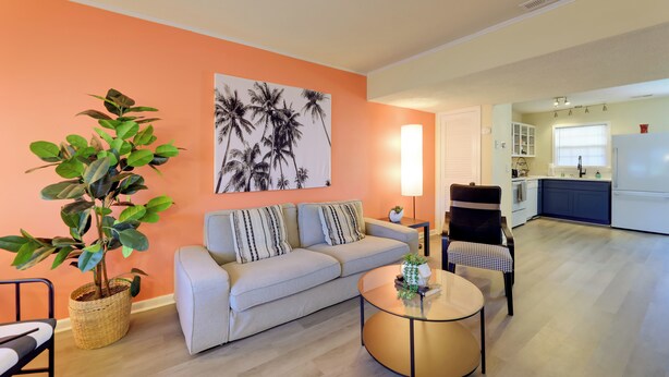 A living room with a sofa, a coffee table, and a potted plant. - Walk to Atlantic Beach: Townhome w/ Patio! (Atlantic Beach)