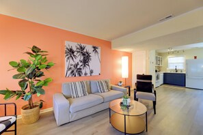 Un salon avec un canapé, une table basse et une plante en pot.