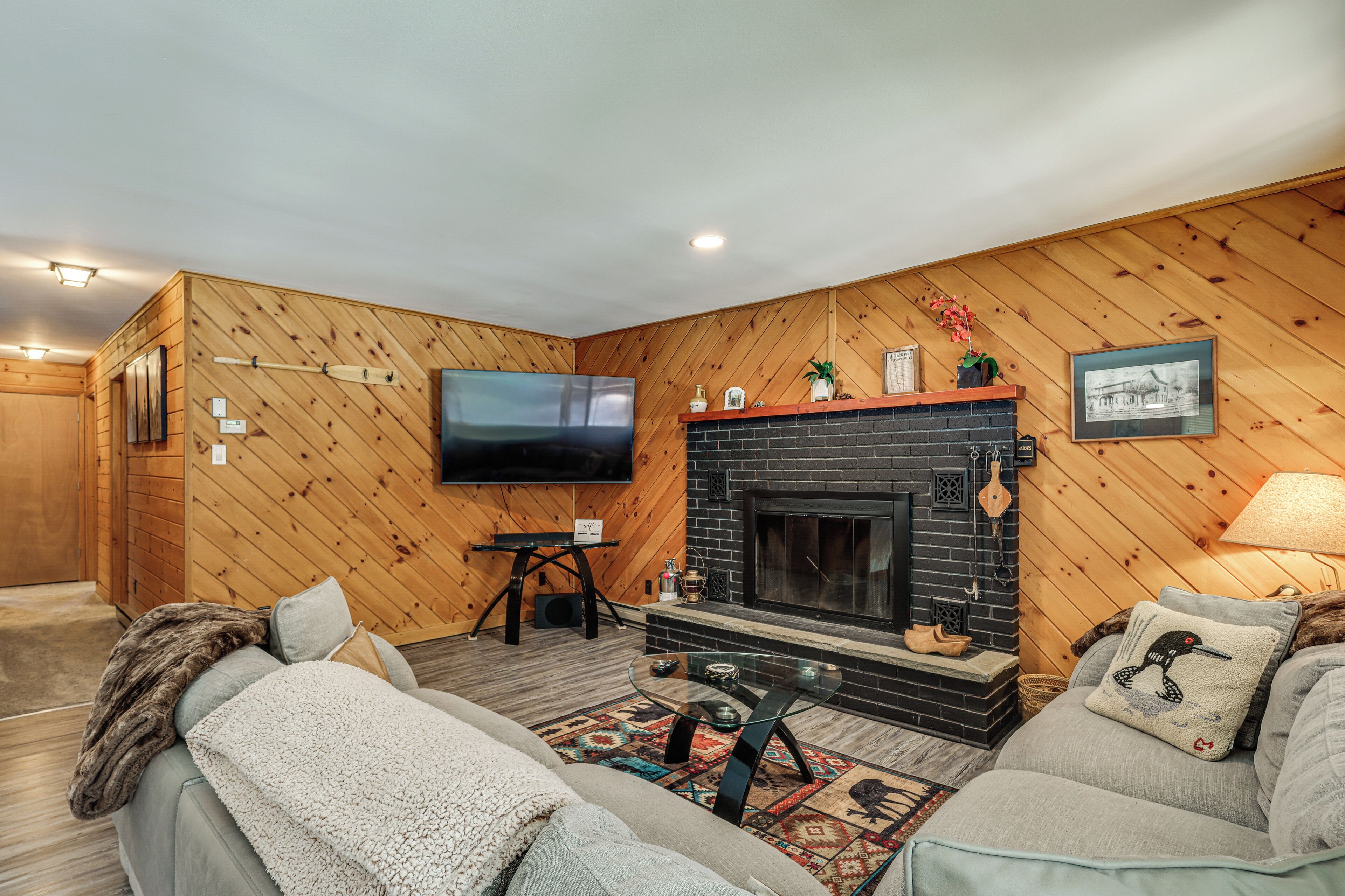 A cozy living room with a fireplace, a television, and a sofa.