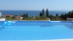 A clear blue swimming pool with a view of the sea and mountains. - Luxury apartment in Opatija for 8 people with pool and silk bedding (Opatija)